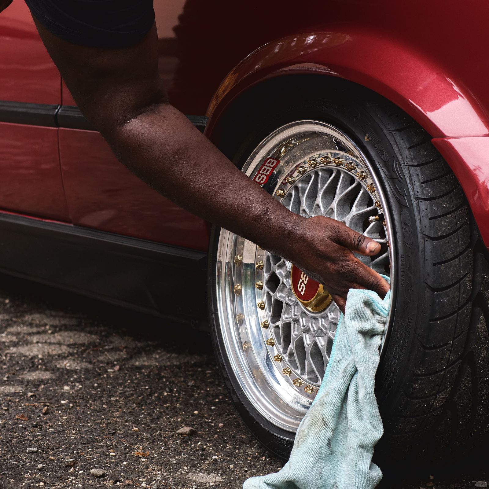 Detailer hand-cleaning a car wheel